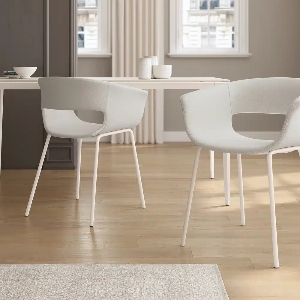 Dos sillones tapizados con brazos junto a la mesa del comedor